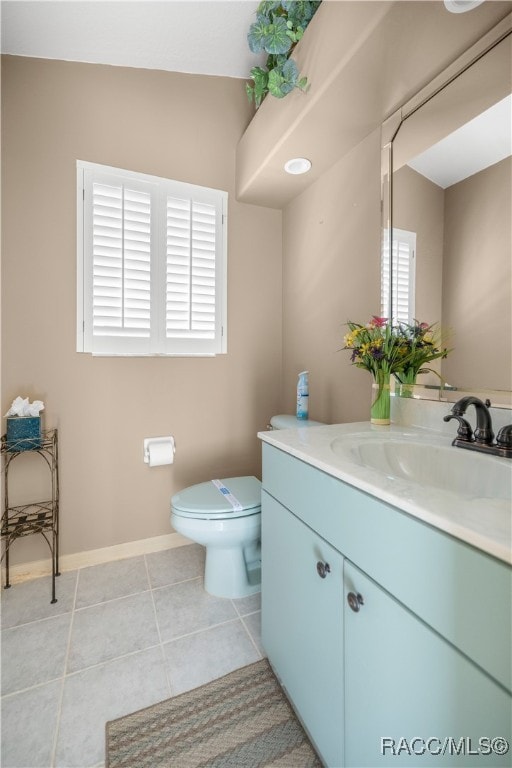 bathroom with tile patterned flooring, vanity, toilet, and vaulted ceiling