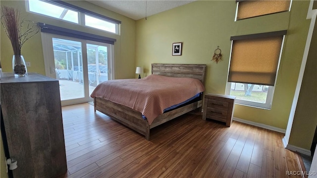 bedroom with access to exterior and hardwood / wood-style floors