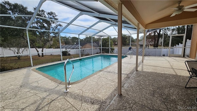 view of pool with ceiling fan, a patio, and glass enclosure