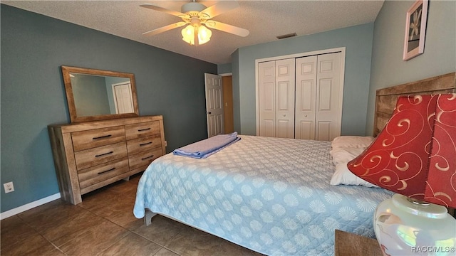 tiled bedroom with ceiling fan, a closet, and a textured ceiling