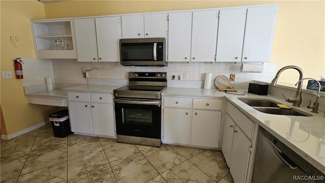 kitchen featuring white cabinetry, appliances with stainless steel finishes, sink, and decorative backsplash