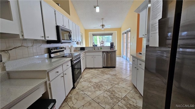 kitchen with sink, white cabinetry, stainless steel appliances, tasteful backsplash, and a textured ceiling