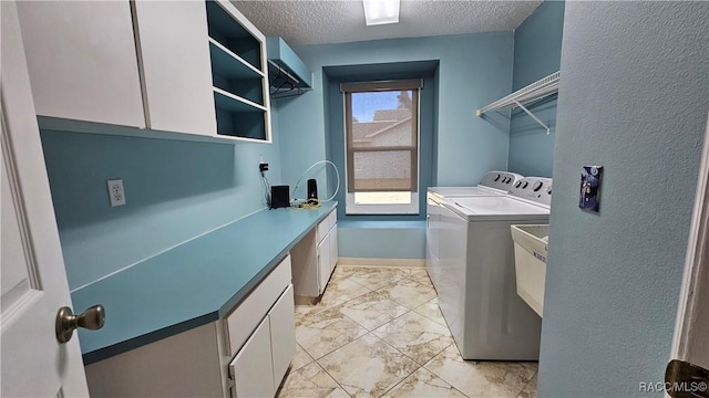 laundry room featuring cabinets, a textured ceiling, and independent washer and dryer