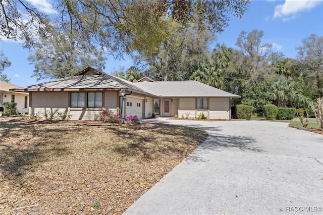 ranch-style home featuring a garage and concrete driveway