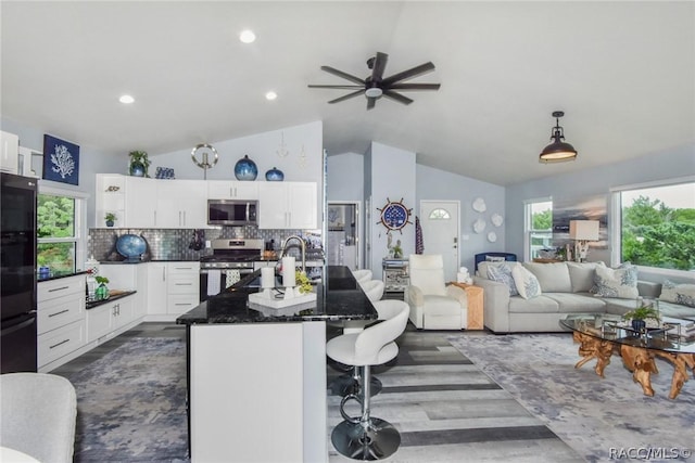 2247 S Waterman Dr, Crystal River, FL 34429 - kitchen with appliances with stainless steel finishes, vaulted ceiling, dark wood finished floors, white cabinetry, and a breakfast bar area