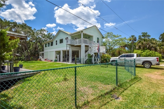 rear view of property featuring a yard and a balcony