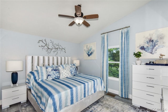 bedroom with ceiling fan, dark wood-type flooring, and vaulted ceiling