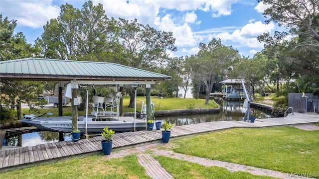 view of dock with a lawn and a water view