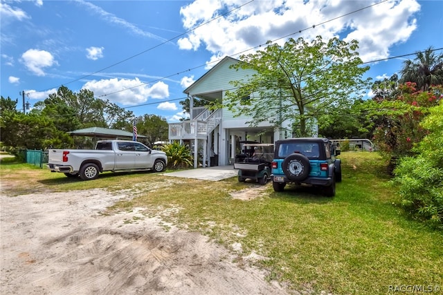 view of property exterior with a carport, covered porch, and a yard