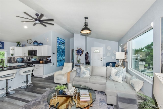 living room featuring ceiling fan, dark wood-type flooring, and lofted ceiling