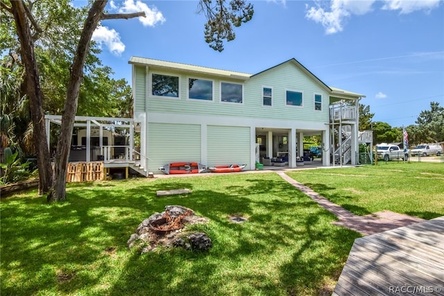 back of house with a yard, a patio, a fire pit, and a wooden deck