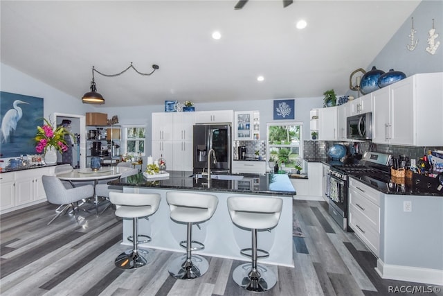 kitchen featuring backsplash, sink, an island with sink, appliances with stainless steel finishes, and dark hardwood / wood-style flooring