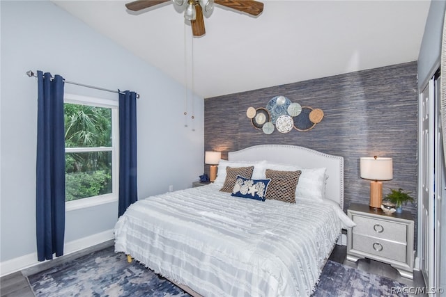 bedroom featuring ceiling fan, dark wood-type flooring, and vaulted ceiling