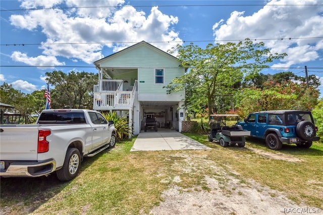 view of front of house with covered porch, a front yard, and a carport