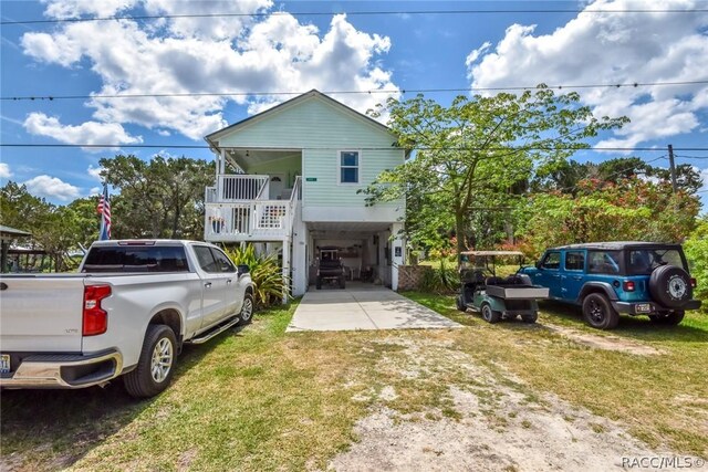 2247 S Waterman Dr, Crystal River, FL 34429 - coastal inspired home with driveway, a front yard, a carport, and stairs