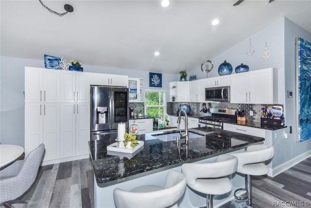 2247 S Waterman Dr, Crystal River, FL 34429 - kitchen featuring stainless steel appliances, tasteful backsplash, dark wood-style floors, white cabinets, and a breakfast bar