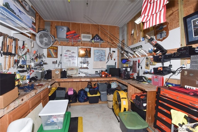 miscellaneous room featuring a workshop area and wood walls