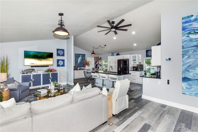 living room with ceiling fan, lofted ceiling, and dark wood-type flooring