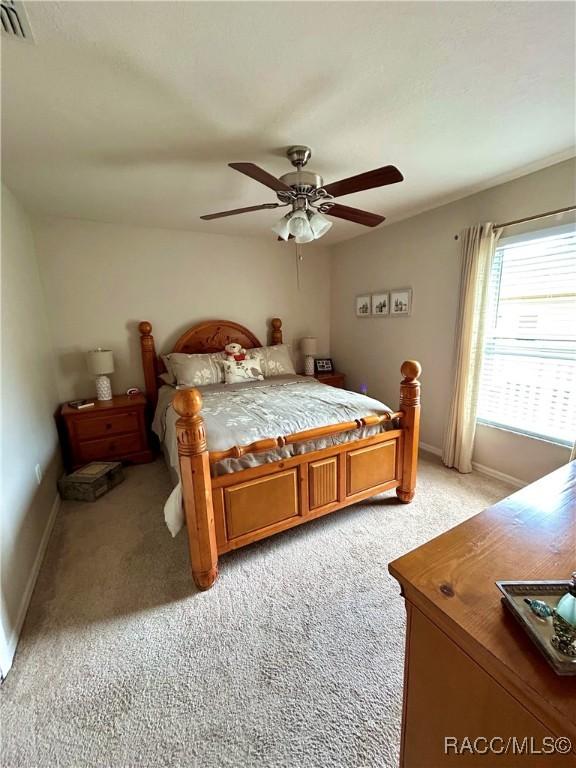 3495 W Wilburton Dr, Citrus Springs, FL 34433 - bedroom with light colored carpet and a ceiling fan