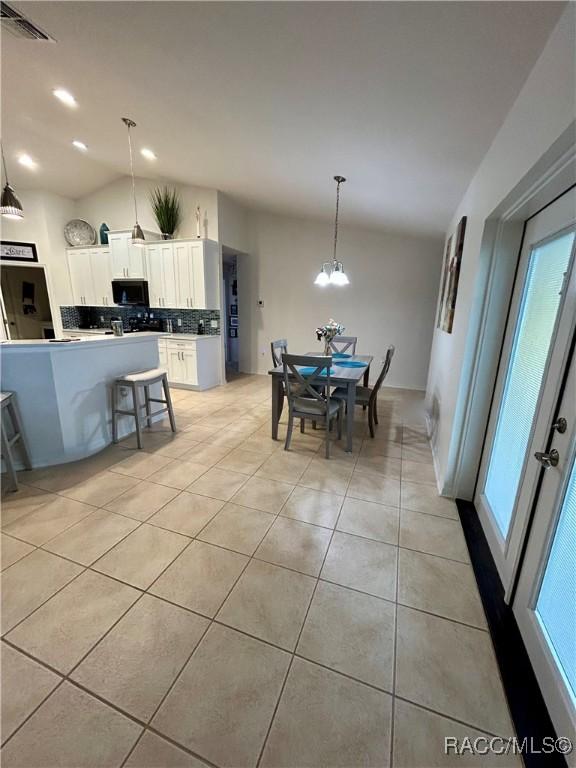 3495 W Wilburton Dr, Citrus Springs, FL 34433 - dining area with light tile patterned floors, lofted ceiling, a chandelier, and recessed lighting