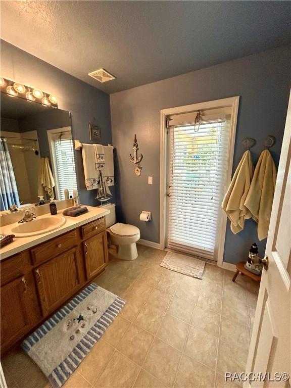 3495 W Wilburton Dr, Citrus Springs, FL 34433 - bathroom featuring vanity, tile patterned floors, a shower with shower door, and a textured ceiling