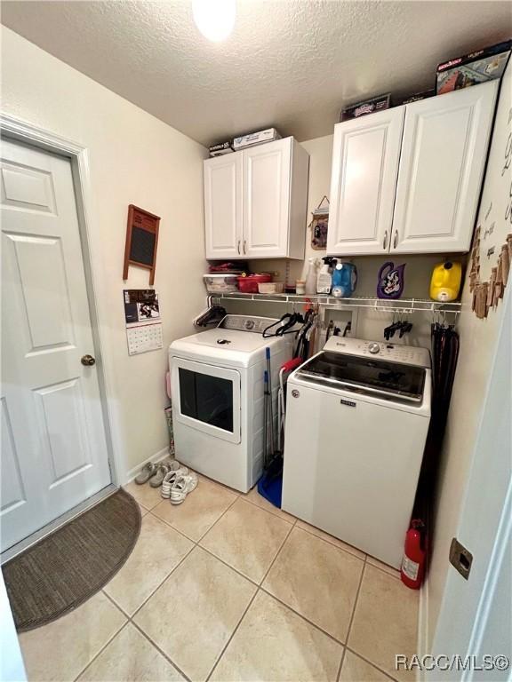 3495 W Wilburton Dr, Citrus Springs, FL 34433 - laundry area featuring cabinet space, independent washer and dryer, a textured ceiling, and light tile patterned floors