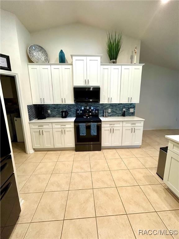 3495 W Wilburton Dr, Citrus Springs, FL 34433 - kitchen with electric range oven, vaulted ceiling, tasteful backsplash, and light tile patterned floors