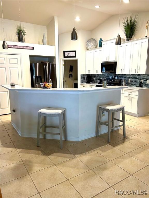 3495 W Wilburton Dr, Citrus Springs, FL 34433 - kitchen featuring black microwave, fridge with ice dispenser, backsplash, vaulted ceiling, and light tile patterned flooring