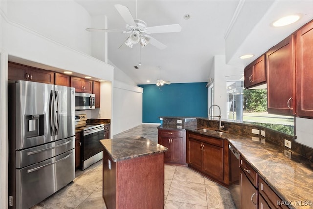 kitchen with dark stone counters, ceiling fan, a center island, and stainless steel appliances