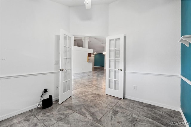 unfurnished room featuring french doors and a towering ceiling