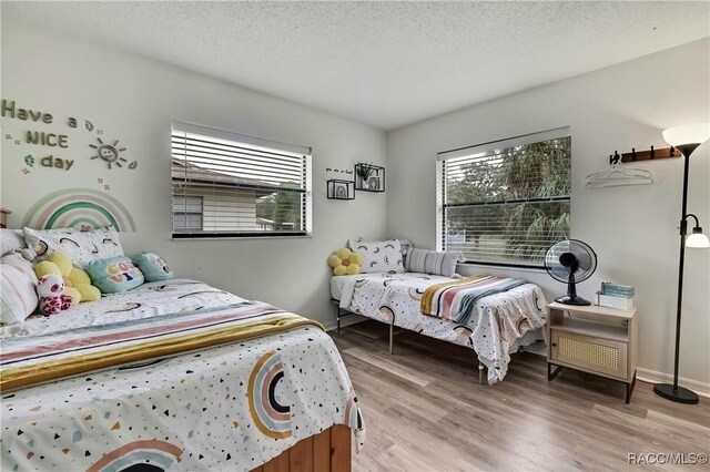 4055 N Little Hawk Pt, Crystal River, FL 34428 - bedroom featuring a textured ceiling, wood finished floors, and multiple windows