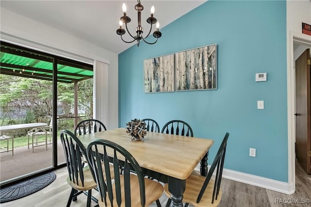 4055 N Little Hawk Pt, Crystal River, FL 34428 - dining area with baseboards, vaulted ceiling, wood finished floors, and a chandelier