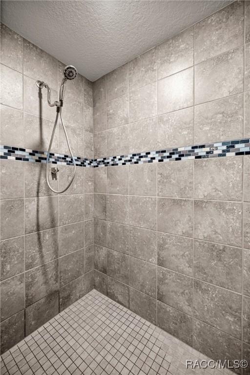 3153 N Chandler Dr, Hernando, FL 34442 - bathroom featuring a tile shower and a textured ceiling