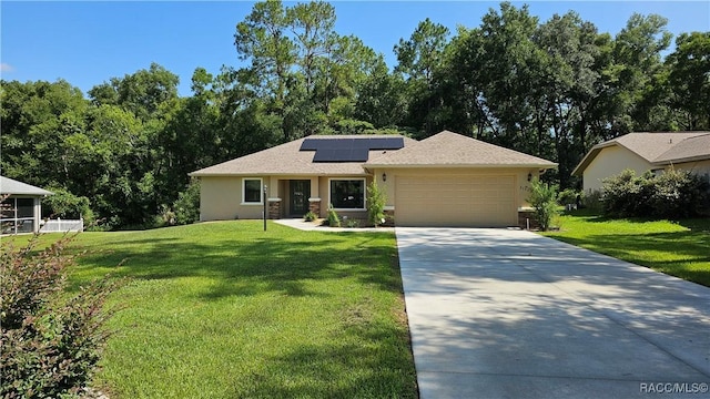 3153 N Chandler Dr, Hernando, FL 34442 - ranch-style house featuring a garage, driveway, a front yard, and roof mounted solar panels