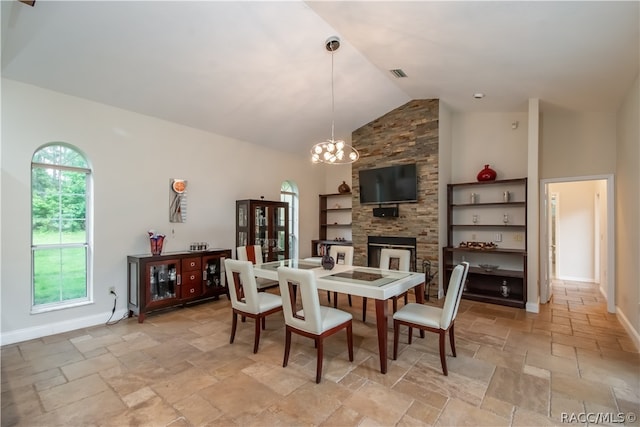 dining space featuring a fireplace, high vaulted ceiling, an inviting chandelier, and built in features