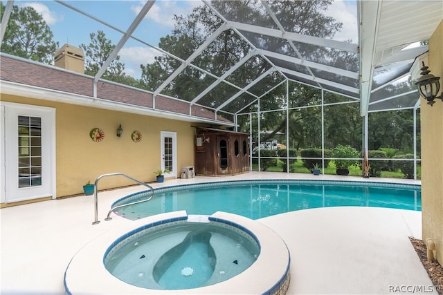 view of swimming pool featuring a lanai, an in ground hot tub, and a patio