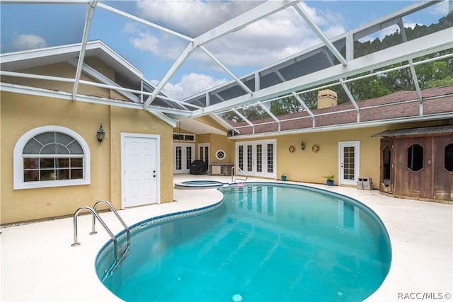 view of swimming pool with an in ground hot tub, french doors, glass enclosure, and a patio area