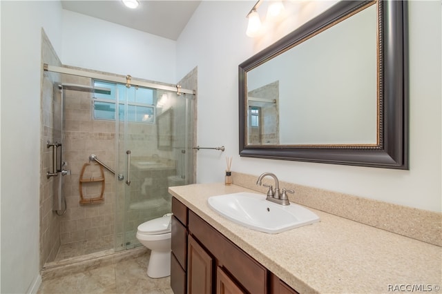 bathroom featuring tile patterned floors, vanity, toilet, and an enclosed shower