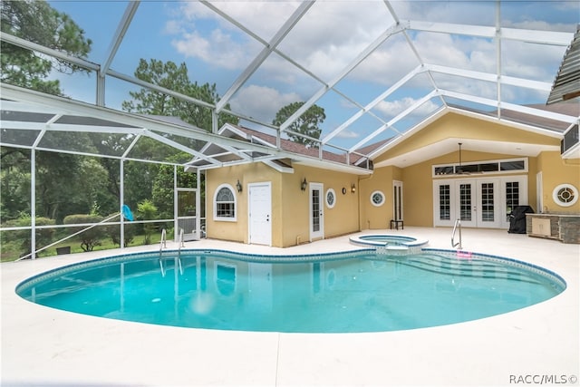 view of swimming pool with a lanai, an in ground hot tub, french doors, and a patio