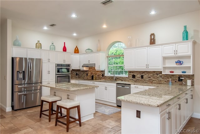 kitchen with white cabinets, appliances with stainless steel finishes, and a kitchen island