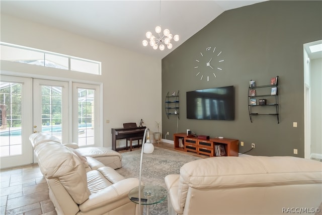 living room with french doors, high vaulted ceiling, and an inviting chandelier