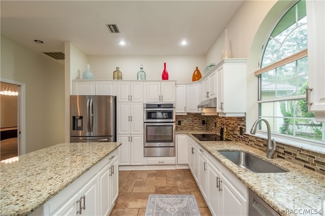 kitchen featuring white cabinetry, light stone countertops, sink, and appliances with stainless steel finishes