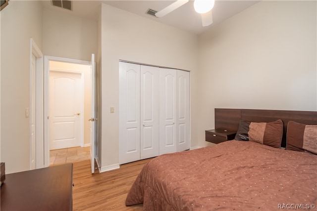 bedroom with a closet, light hardwood / wood-style flooring, and ceiling fan