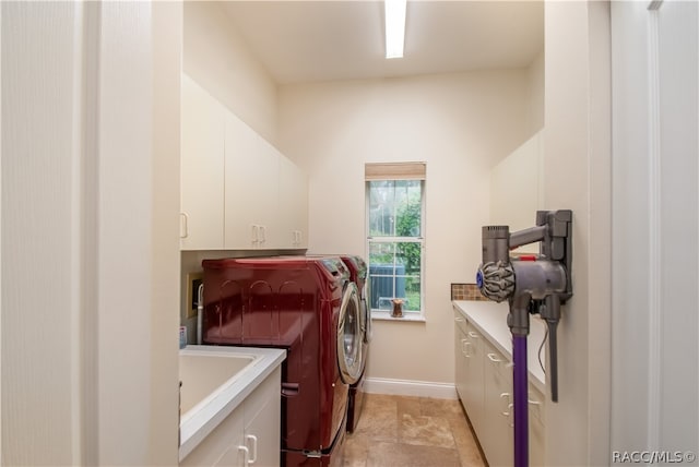 clothes washing area with washer and dryer and cabinets