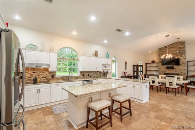 kitchen with a center island, stainless steel appliances, kitchen peninsula, pendant lighting, and a breakfast bar area