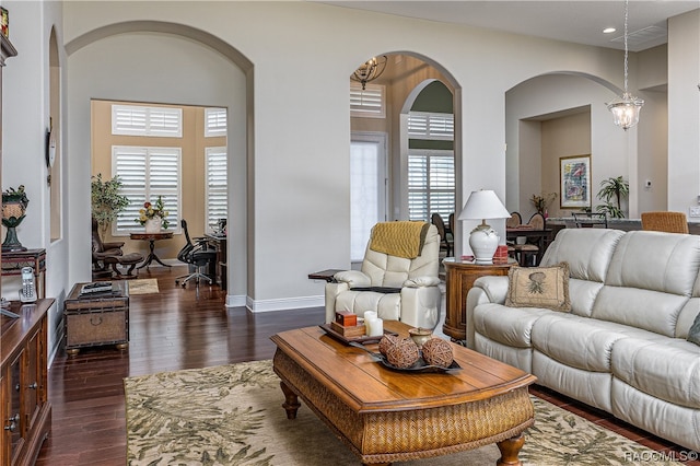 living room featuring plenty of natural light, a chandelier, and dark hardwood / wood-style floors