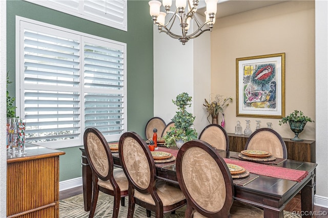 dining space with hardwood / wood-style flooring, a healthy amount of sunlight, and a chandelier