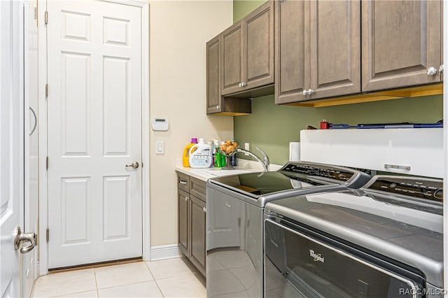 laundry room featuring cabinets, sink, separate washer and dryer, and light tile patterned flooring