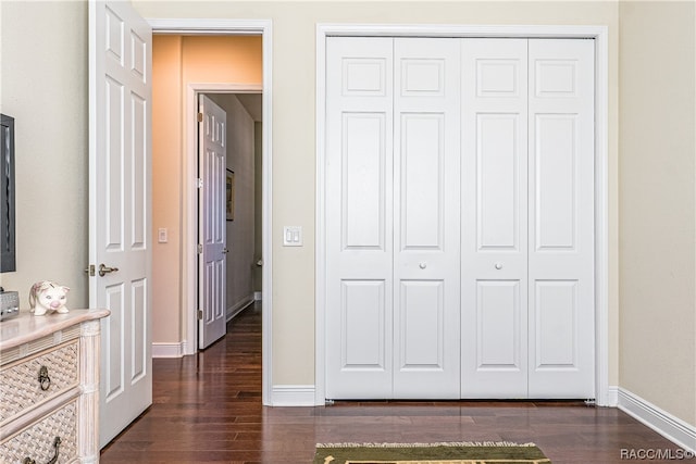 unfurnished bedroom featuring dark wood-type flooring and a closet