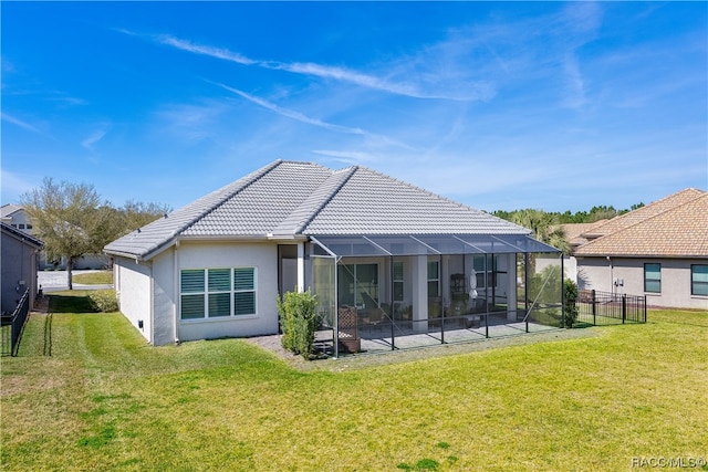 back of house featuring a lawn, a lanai, and a patio